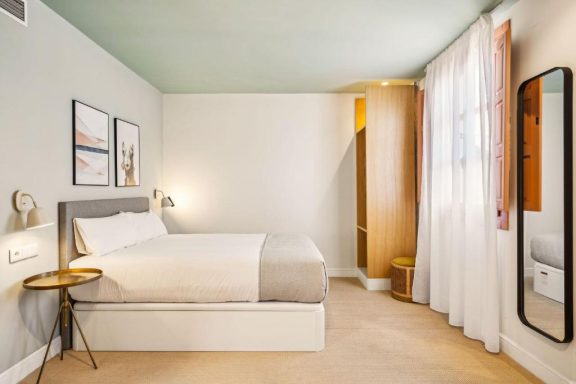 Habitación luminosa con cama doble, mesas de noche y decoración minimalista.